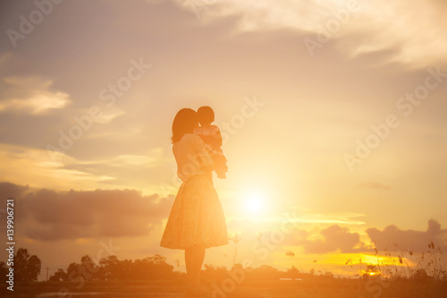 Happy Mother with baby sunset.