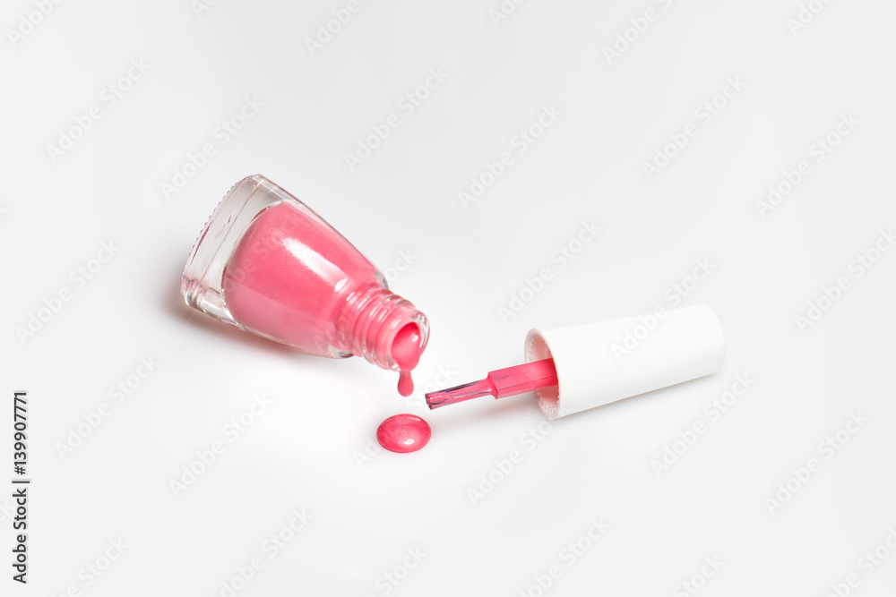 Spilled pink nail polish and brush on white background. Fashion woman still life. Pop female things Spilled pink nail polish and brush on white background. Fashion woman still life. Pop female things