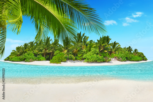 Whole tropical island within atoll in tropical Ocean and inscription "Vacations" in the sand on a tropical island.