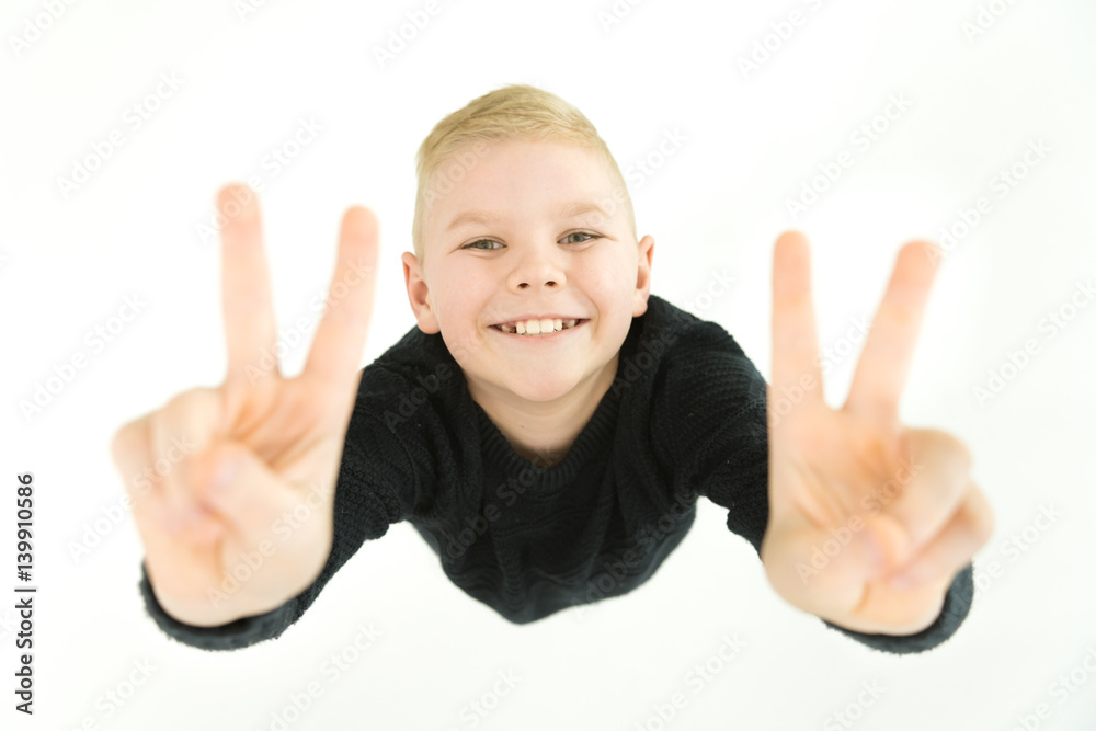 The happy boy gesture to the camera. View from above The happy boy gesture to the camera. View from above