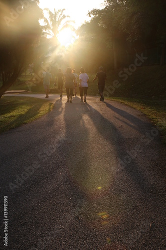 Group of people jogging into sunrise