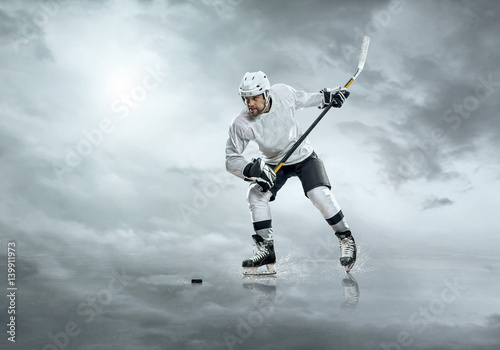 Ice hockey player in action outdoor under sky with clouds