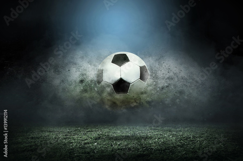 Moving soccer ball around splash drops on the stadium field. © Andrii IURLOV