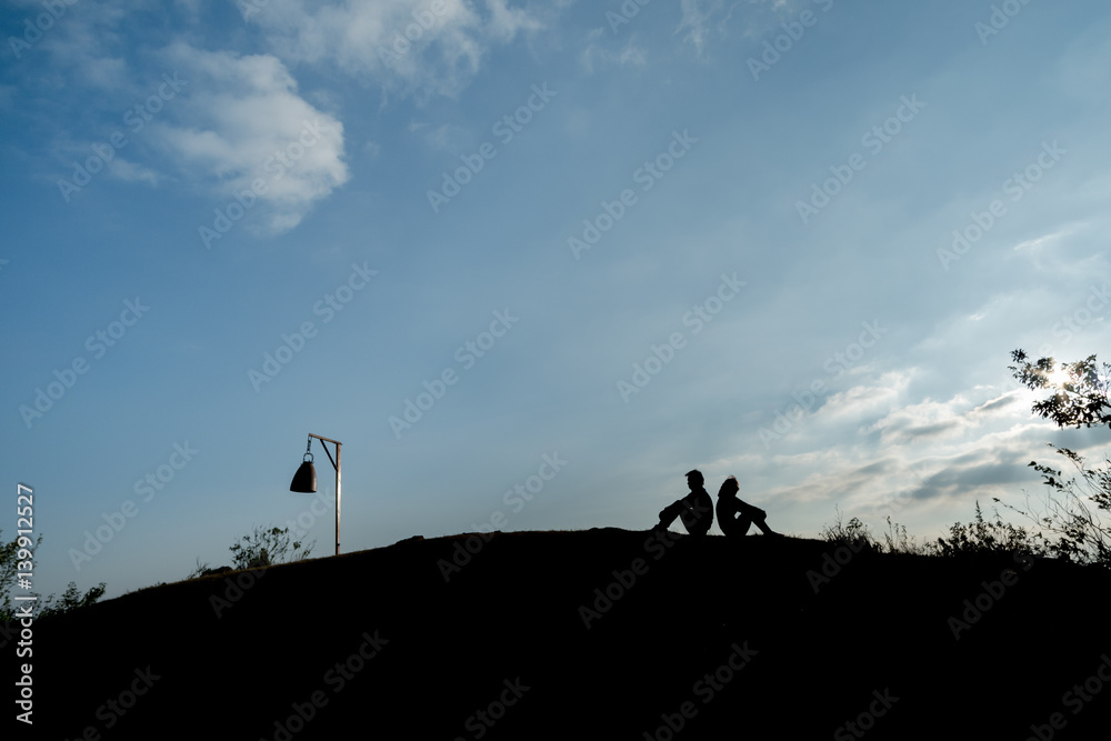 silhouette man and woman sitting at hill silhouette man and woman sitting at hill