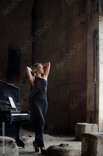 fashion girl in black dress in grunge interior with the piano