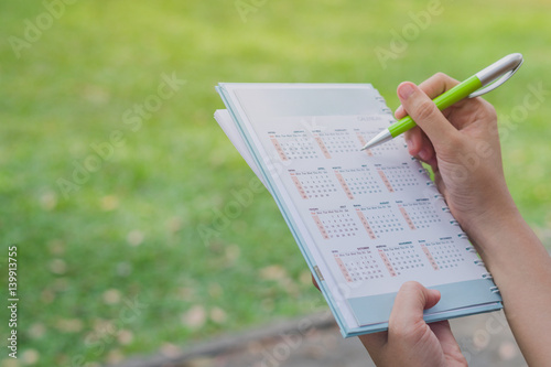 Business holding a calendar with nature background, Business marking a calendar