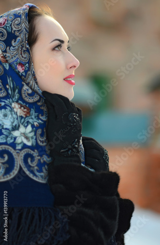 Portrait of beautiful brunette girl in a blue scarf in the winter