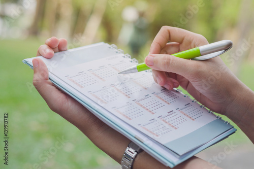 Business holding a calendar with nature background, Business marking a calendar