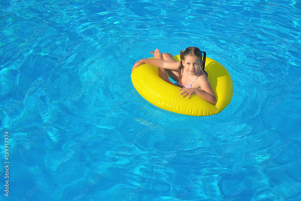 Toddler girl relaxing in swimming pool