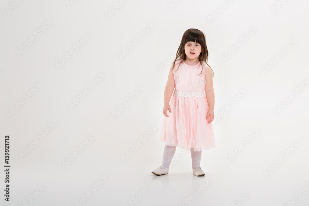 beautiful little girl in pink Princess dress on a gray backgroun beautiful little girl in pink Princess dress on a gray backgroun