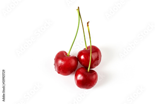 Three fresh ripe cherries isolated on white background