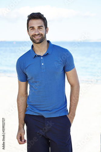 Happy dude in blue on beach, portrait