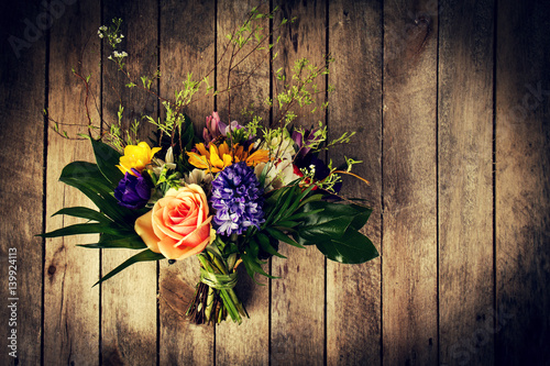 Beautiful bunch of flowers on wooden background. Horizontal. View from above. Toning.