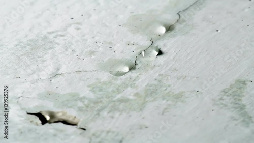 Water drips from ceiling. Faulty water supply in high-rise building. Cracked plaster on the ceiling.