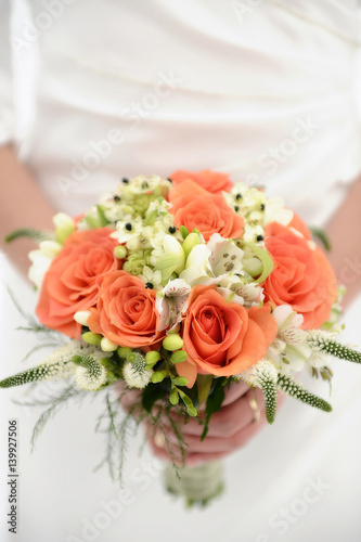 White Caucasian bride holding a colorful wedding bouquet