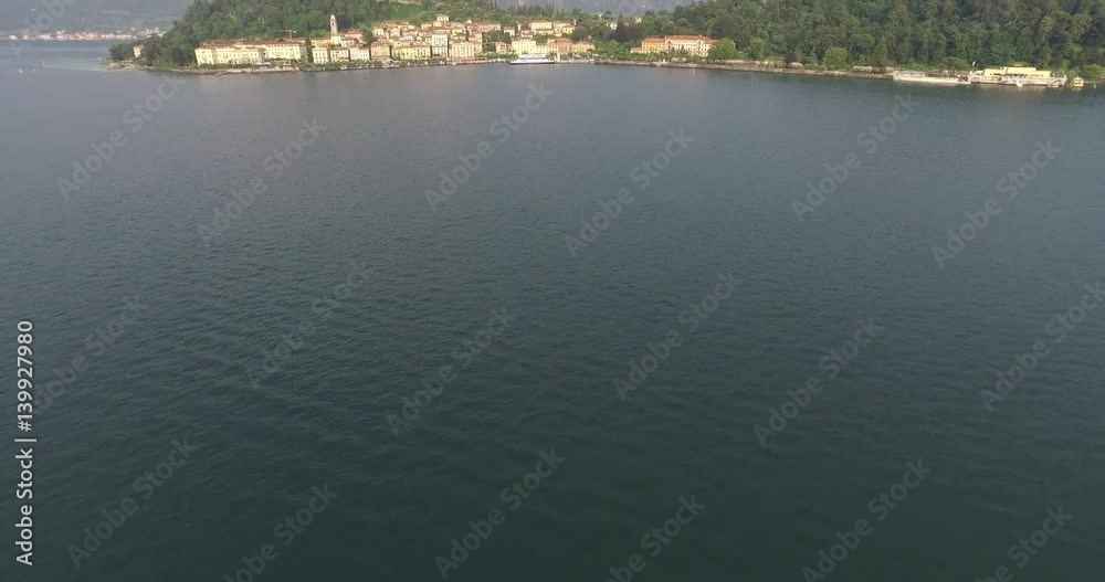 View of the harbor city with the background of foggy mountains. Lake Como, Italy View of the harbor city with the background of foggy mountains. Lake Como, Italy