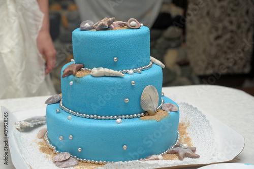 Wedding cake in white and blue combination, adorned with flowers, ribbons and butterflies photo