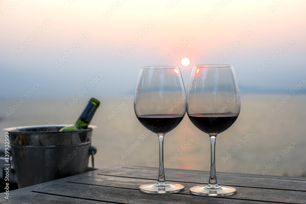 wine in glasses on the table for couple lovers celebration at sunset in background