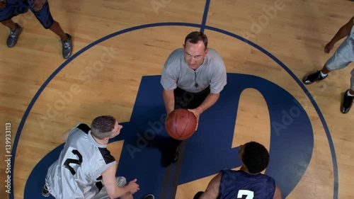 Slow-motion overhead view of basketball players at tipoff