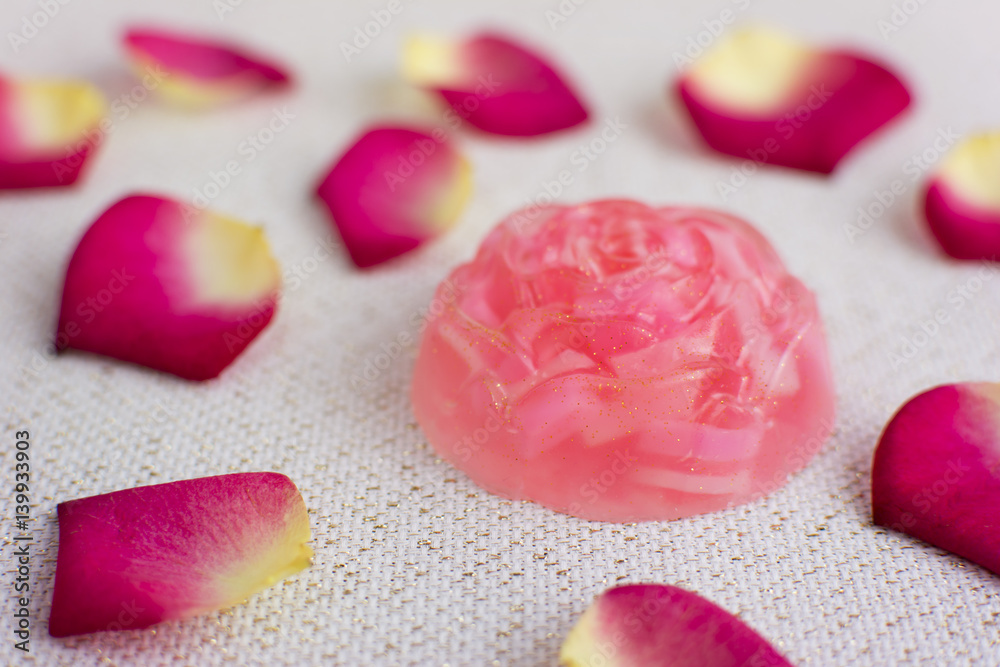 Organic homemade rose soap. Delicate rose petals on the background. Organic homemade rose soap. Delicate rose petals on the background.