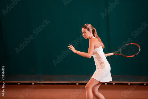 Indoor tennis court playing athlete.