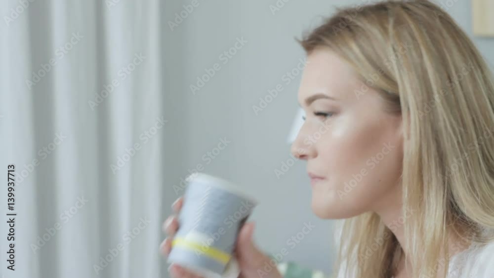 Beautiful woman in white is drinking close-up Beautiful woman in white is drinking close-up