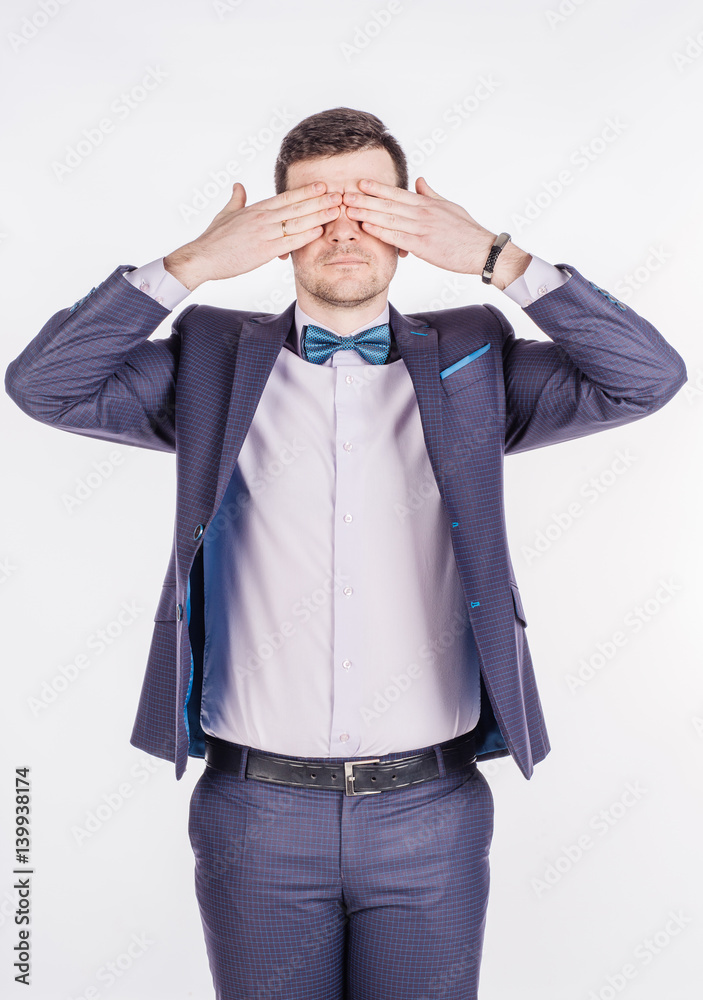 portrait young businessman covering his eyes with his hand. emotions, facial expressions, feelings, body language, signs. image on a white studio background.