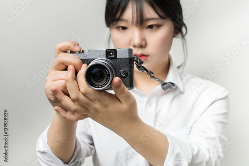 Female hand holding modern camera (mirrorless camera). camera in hand. Focus camera