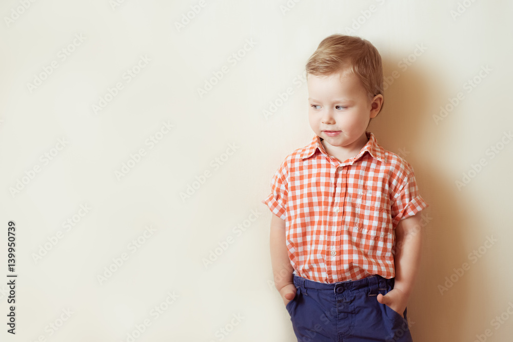 Little boy stands in a shirt and slacks, hands in pockets Little boy stands in a shirt and slacks, hands in pockets