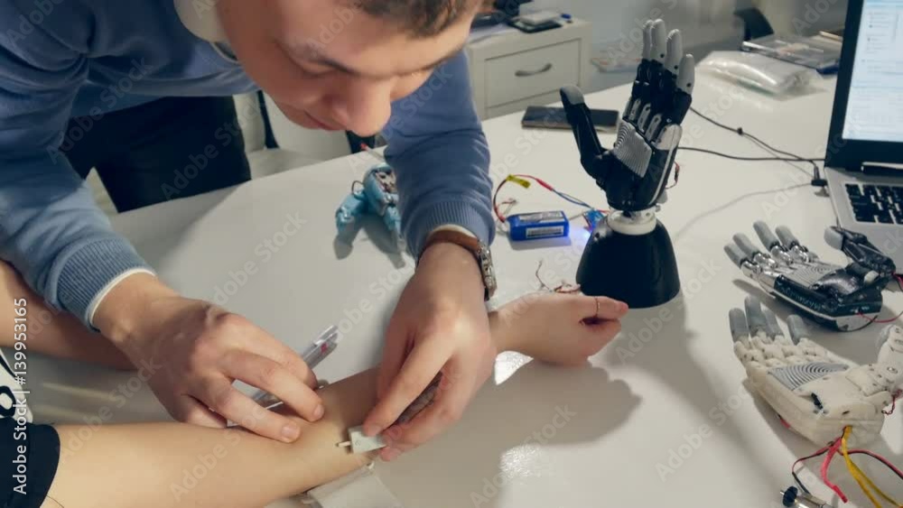 Engineer hands set up innovative bionic robotic arm, modern prosthesis on female hand. 4K.