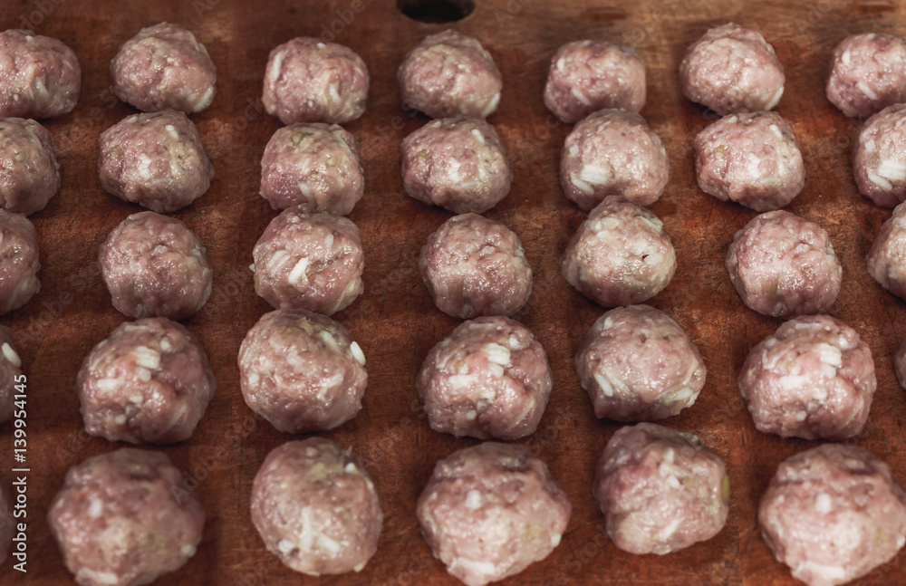 Home food, raw meatballs on a wooden board rural food