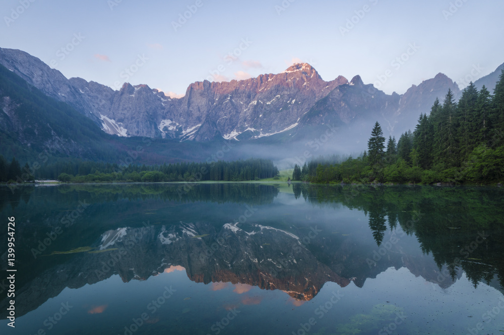 sunrise over the crystal-clear mountain lake in the Julian Alps