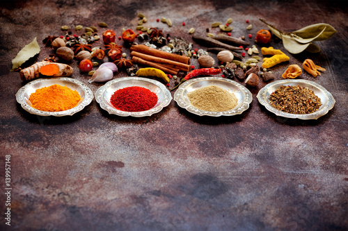 Spices and herbs in silver bowls on a rusty old background and space for text photo