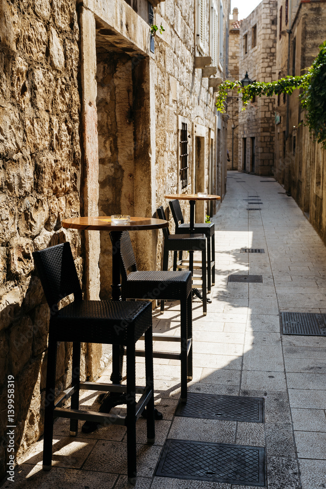 Chair and table of the restaurant on a narrow European street in the historic city.