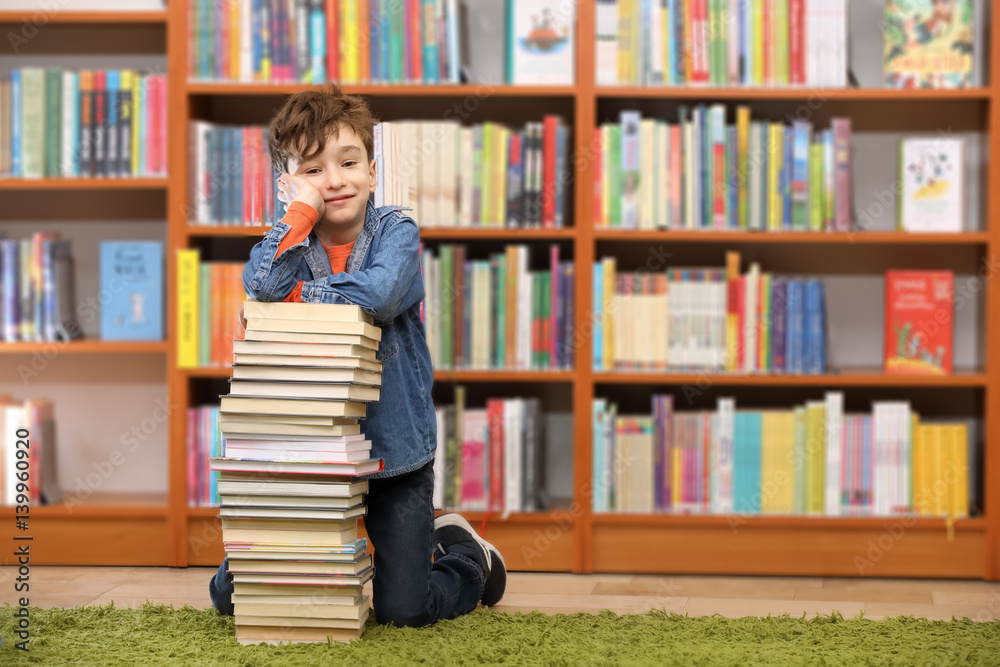 Cute boy reading book in library