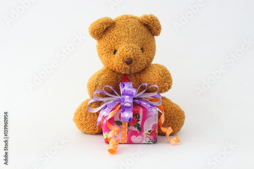 Brown teddy bear and gift boxes on a white background.