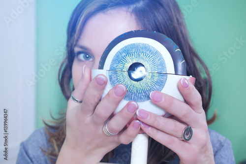 Ophthalmology oculus sample closeup. Ophthalmology, eye model close-up. The girl is holding a model of the eye. photo