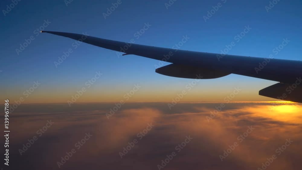 Clouds and beautiful sunrise. View from the window of an airplane wing, clouds and a beautiful sunrise.