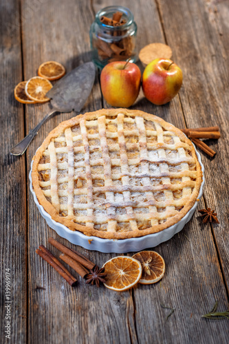 Homemade apple pie and ingredients on a rustic table