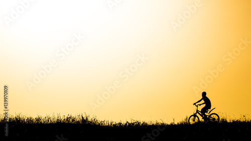 Bicycle boy Orange background,Silhouette.