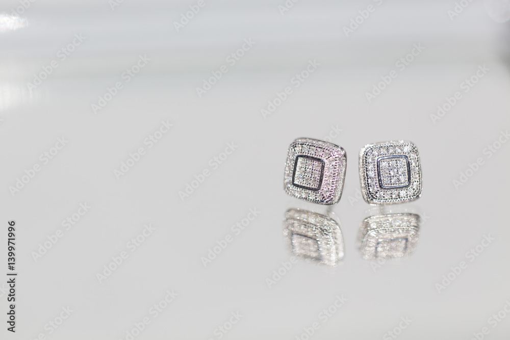 two earrings or cufflinks placed one beside the other 