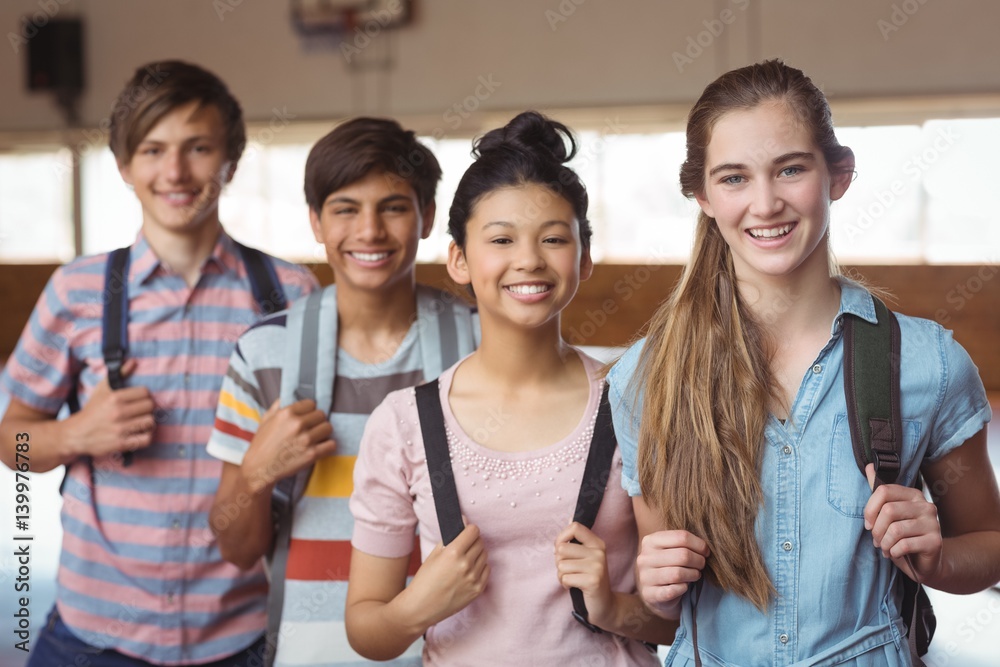 Portrait of happy students standing with schoolbags in campus Portrait of happy students standing with schoolbags in campus