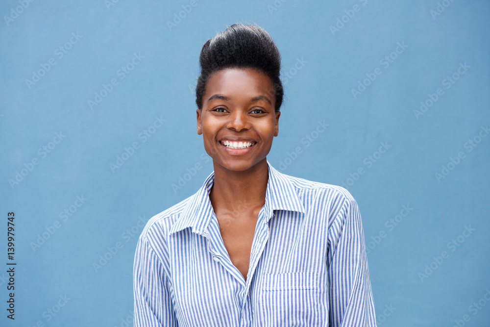 Fototapeta premium beautiful young black woman smiling against blue background