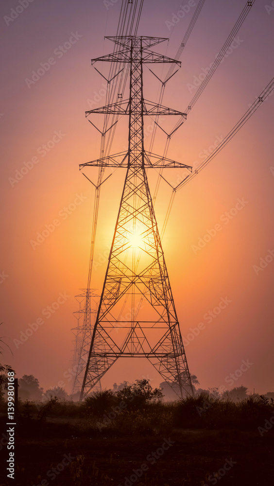 high voltage post.High-voltage tower with sunrise