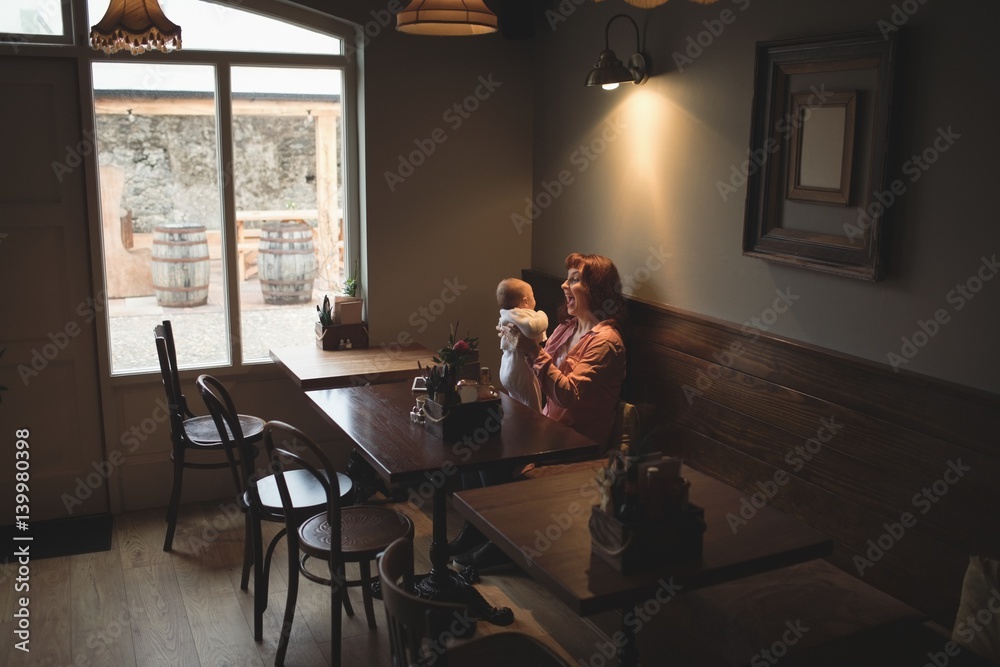 Mother playing with her baby in café Mother playing with her baby in café