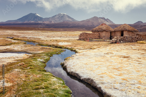 Tourist bathing in hot springs, Sajama national park, with volcano Parinacota and Pomerape in the background, Bolivia photo