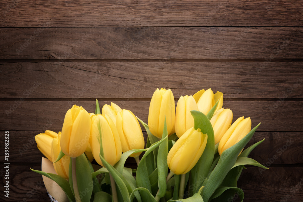 Naklejka premium Fresh yellow tulips on rustic wooden table