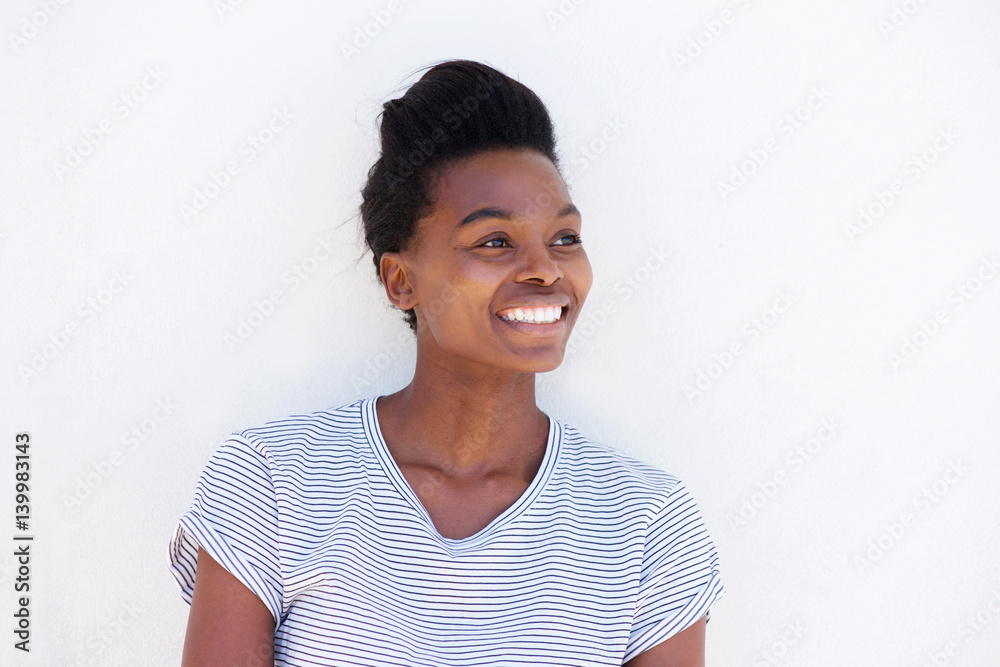 smiling young black woman posing against white wall smiling young black woman posing against white wall