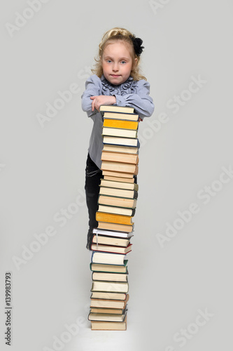 education and school concept - little student girl with many books