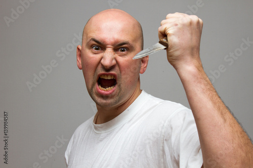 Foto Enraged man with a knife in a murderous rage